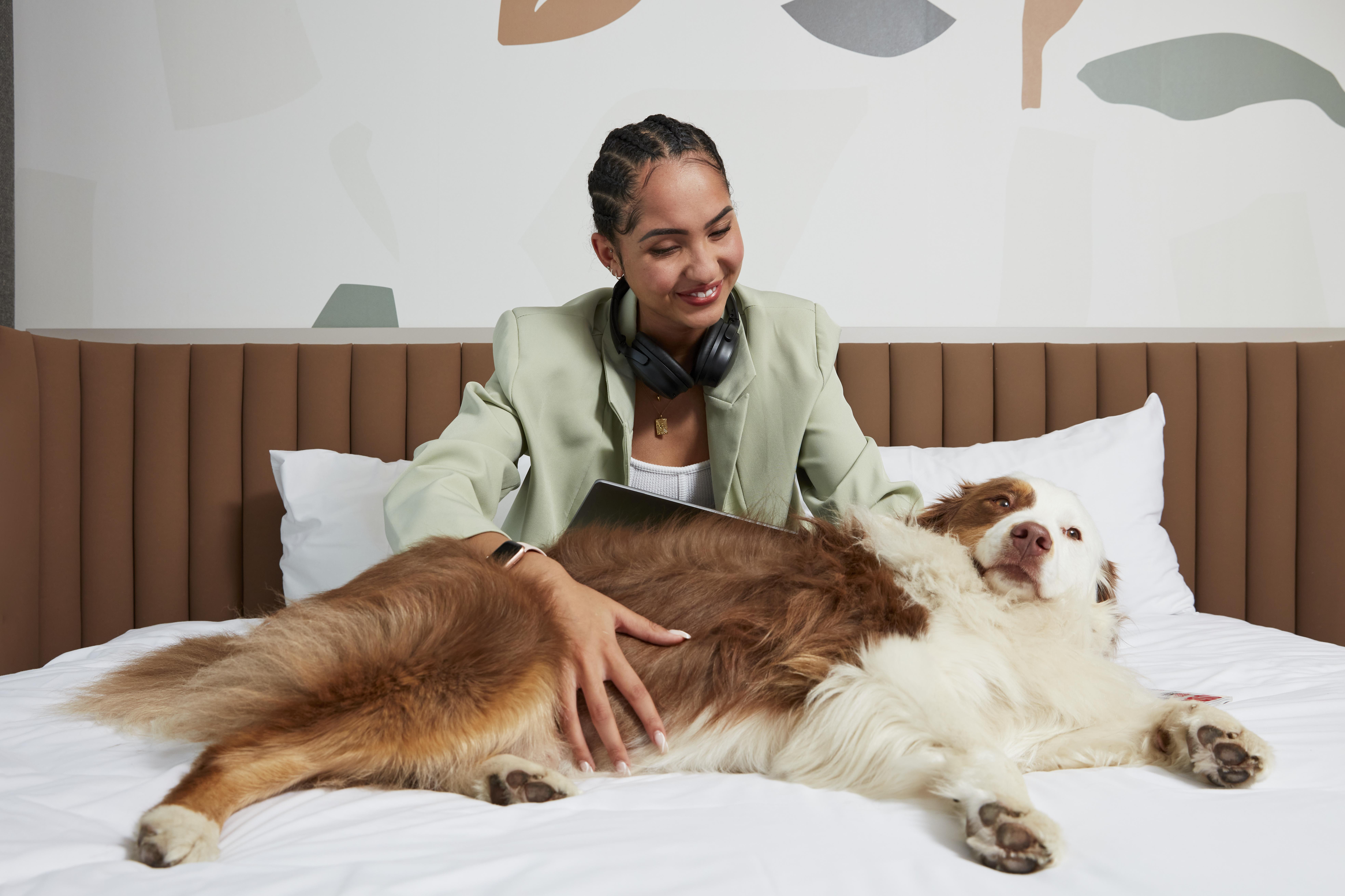 Frau in einem Hotel mit ihrem Haustier (Hund)